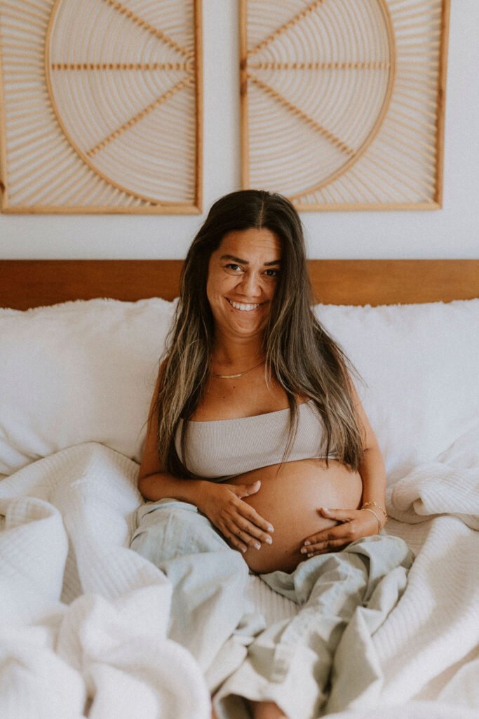 Pregnant woman with Spinal Muscular Atrophy smiling during intimate maternity photoshoot