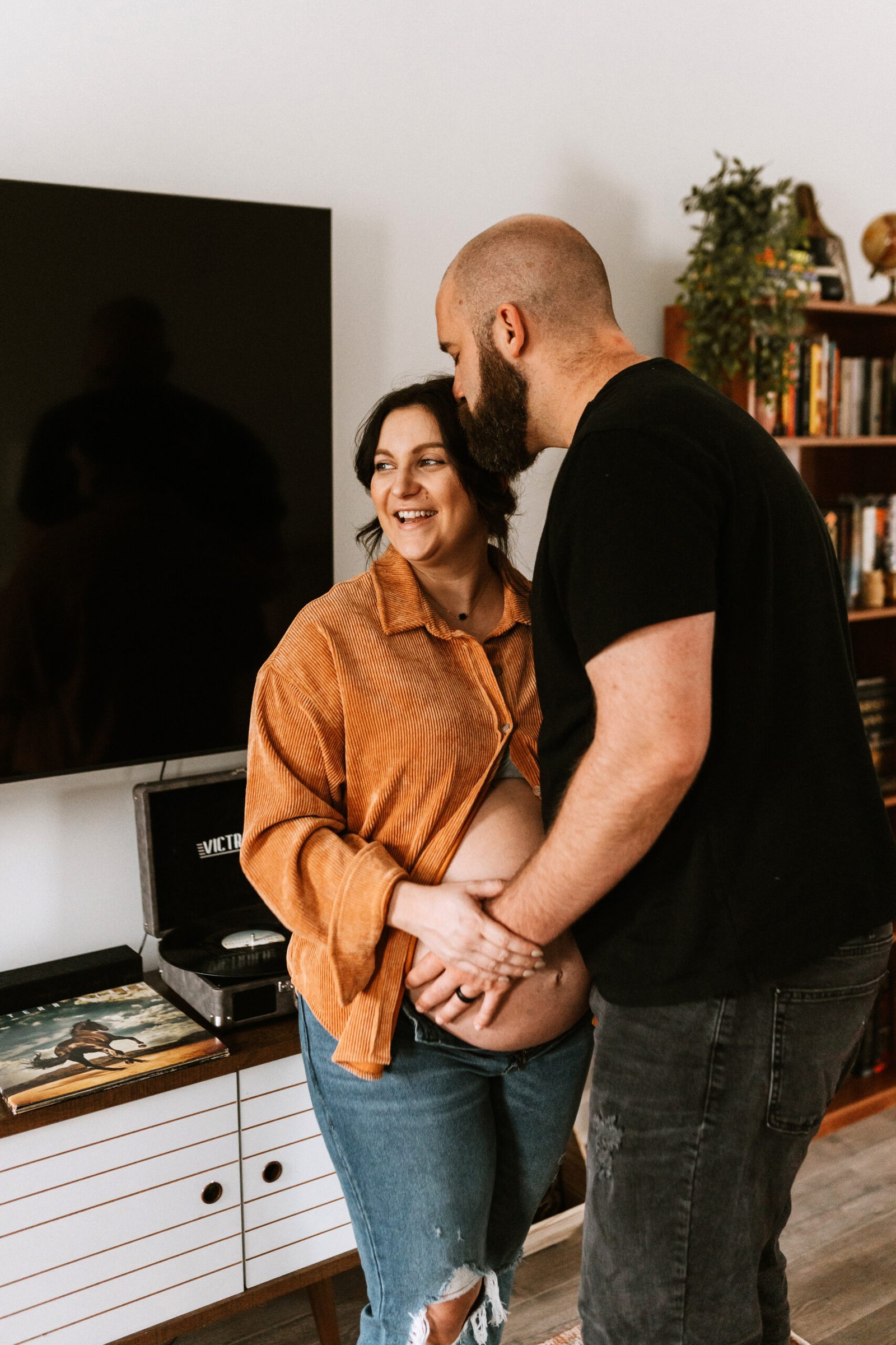 mom and dad holding belly during in home maternity session